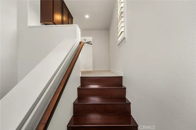 a view of staircase with wooden floor and white walls
