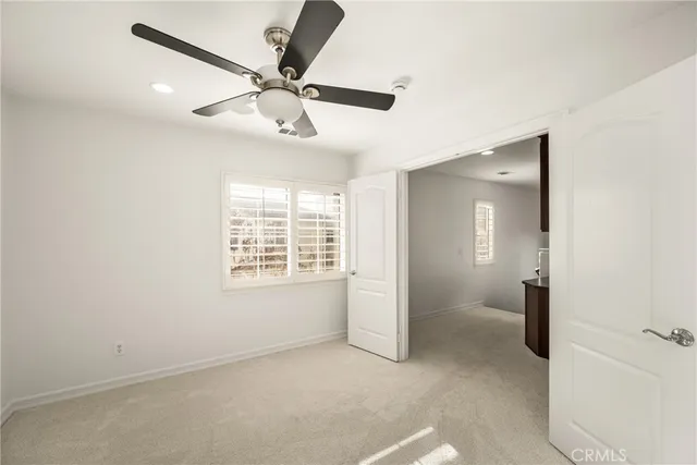 an empty room with a window and a fan