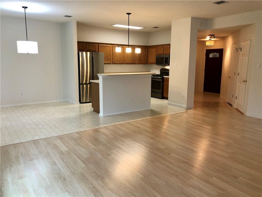 1515 Lochaline Loop Pflugerville, TX 78660 - Photo 12 of 12 Kitchen with open floor plan, stainless steel appliances, hanging light fixtures, and brown cabinets