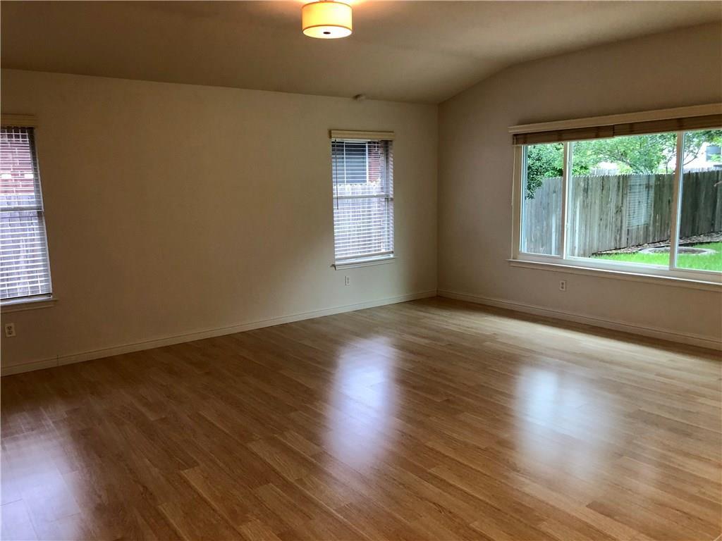 1515 Lochaline Loop Pflugerville, TX 78660 - Photo 6 of 12 Unfurnished room featuring wood finished floors, lofted ceiling, and plenty of natural light