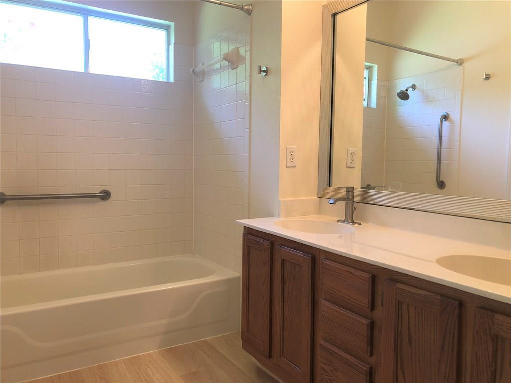 1515 Lochaline Loop Pflugerville, TX 78660 - Photo 7 of 12 Bathroom featuring double vanity, shower combination, and light wood-style floors
