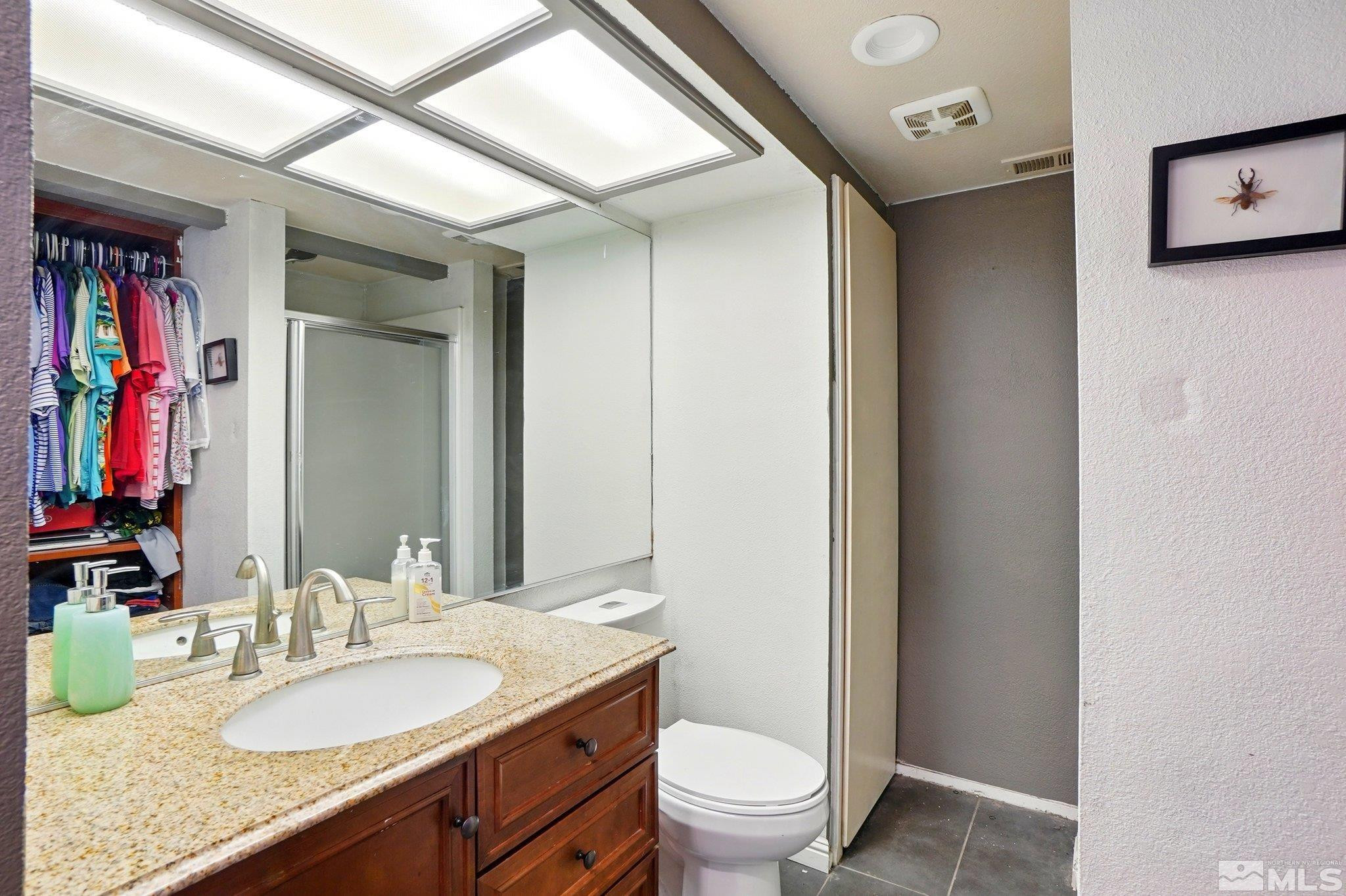 4185 Baker Lane Reno, NV 89509 - Photo 17 of 21 a bathroom with a granite countertop sink mirror vanity and toilet