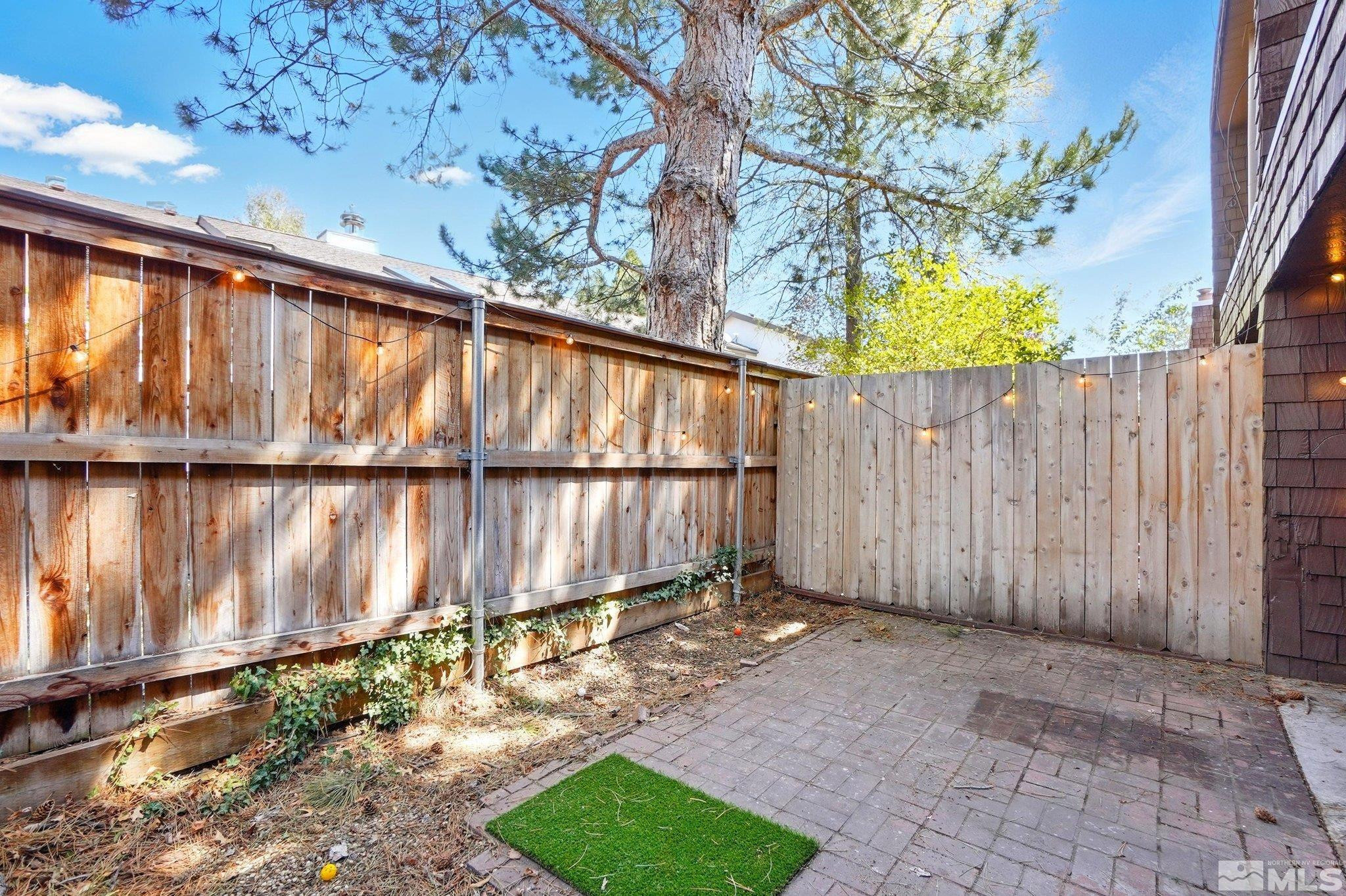 4185 Baker Lane Reno, NV 89509 - Photo 19 of 21 a view of backyard with wooden fence and large trees