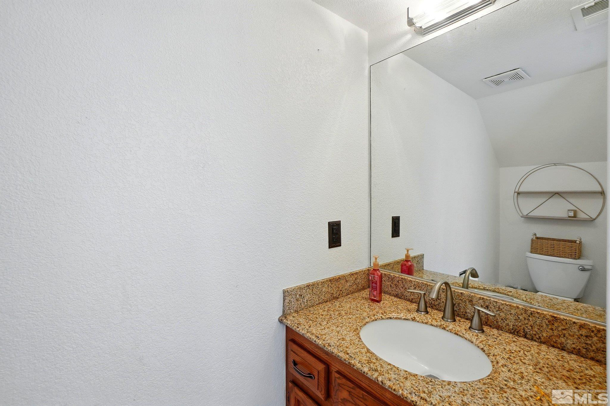 4185 Baker Lane Reno, NV 89509 - Photo 4 of 21 a bathroom with a granite countertop sink and a mirror