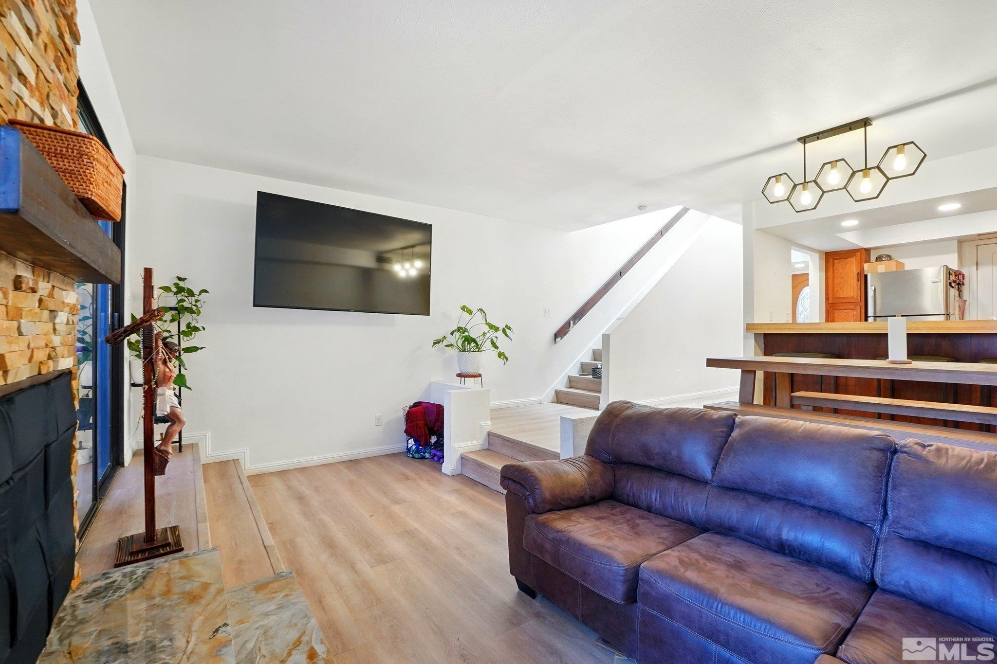 4185 Baker Lane Reno, NV 89509 - Photo 8 of 21 a living room with furniture a flat screen tv and a floor to ceiling window