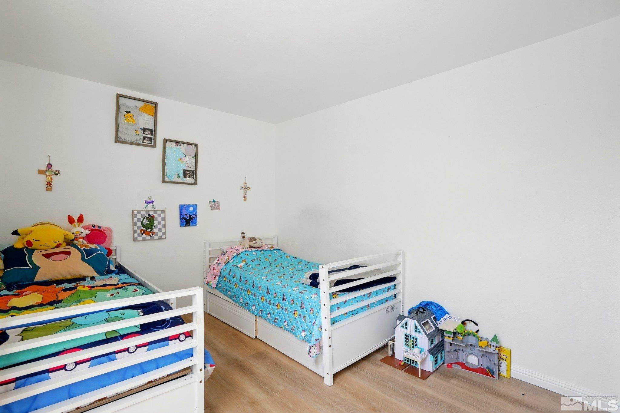4185 Baker Lane Reno, NV 89509 - Photo 10 of 21 a bedroom with baby bed and wooden floor