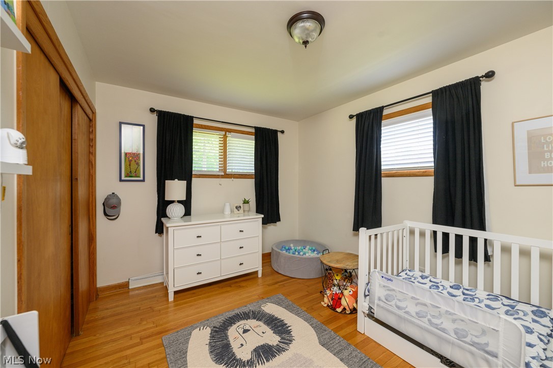 1243 Garman Road Akron, OH 44313 - Photo 17 of 21 Bedroom featuring a nursery area, a closet, and light wood-type flooring