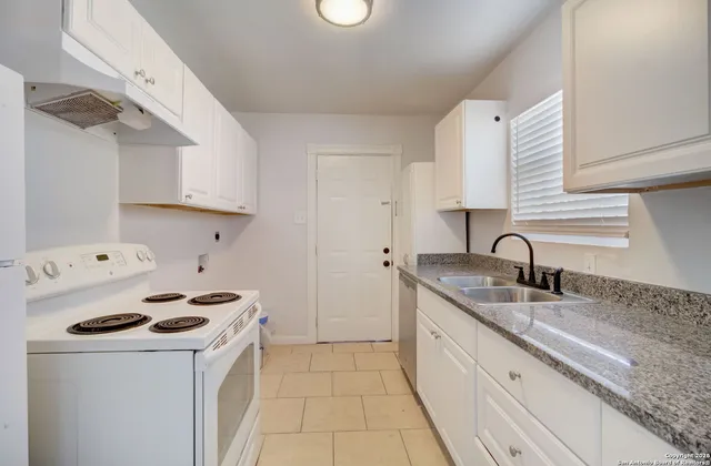 a kitchen with a sink a stove and cabinets