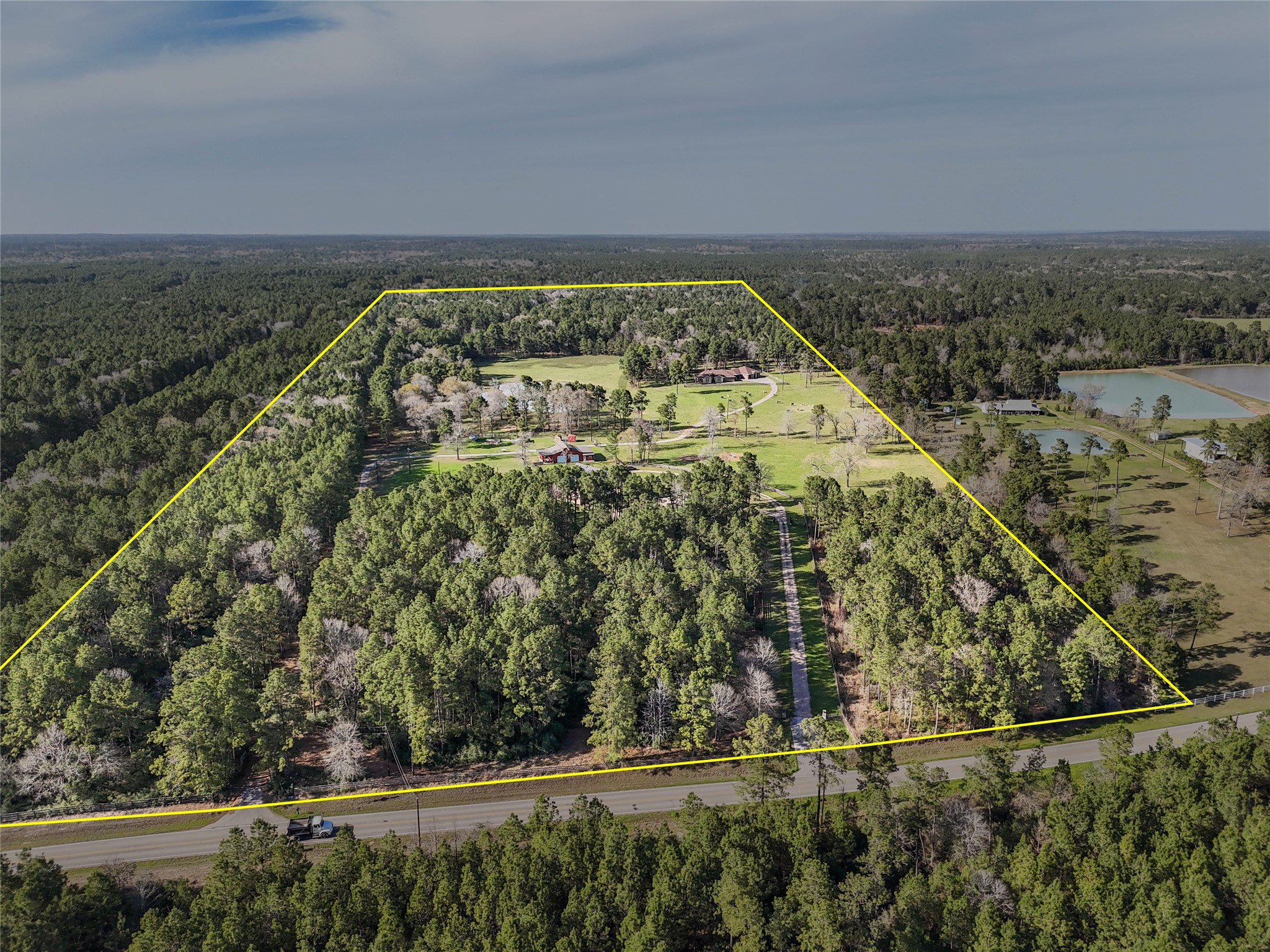 26250 A Riley Road Waller, TX 77484 - Photo 2 of 50 Set on a vast stretch of wooded land, this property offers seclusion and countless possibilities, with a picturesque drive leading to the residence, retreat, barn, and cabin.