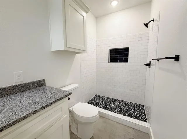 a bathroom with a granite countertop sink a mirror and a shower
