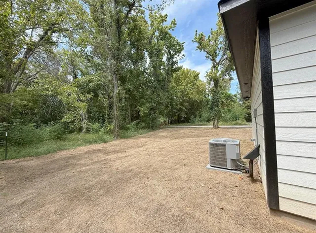 a front view of house with yard and trees in the background