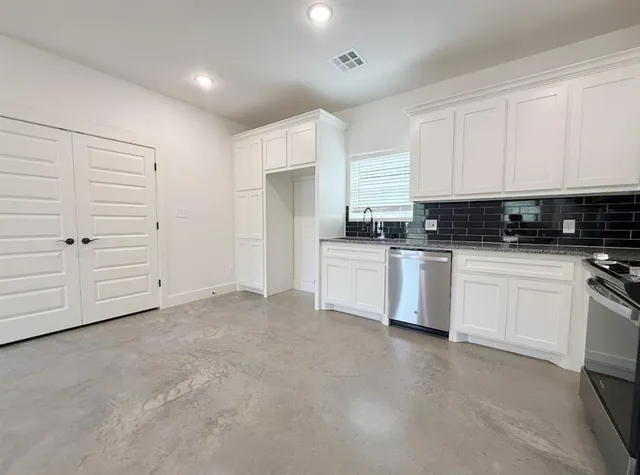 an empty room with a window and a fan