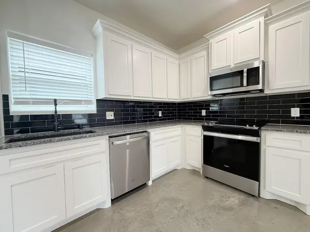 a kitchen with white cabinets and white appliances