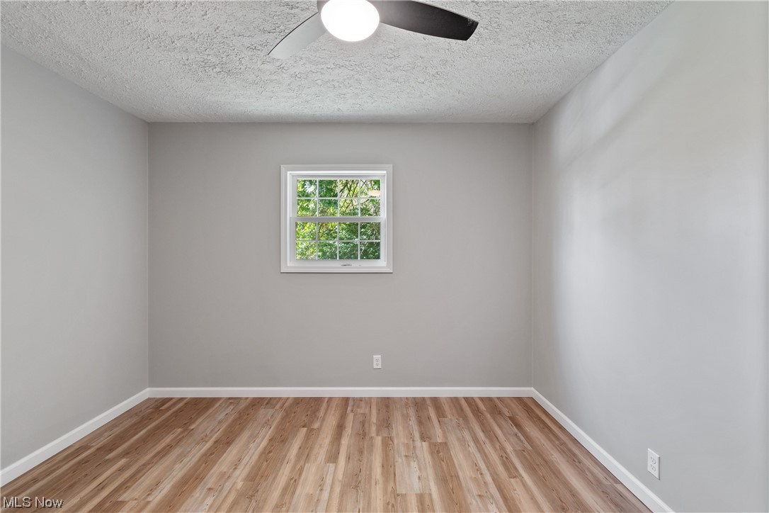 59636 Broadview Road Shadyside, OH 43947 - Photo 21 of 31 Spare room featuring ceiling fan, light hardwood floors, and a textured ceiling