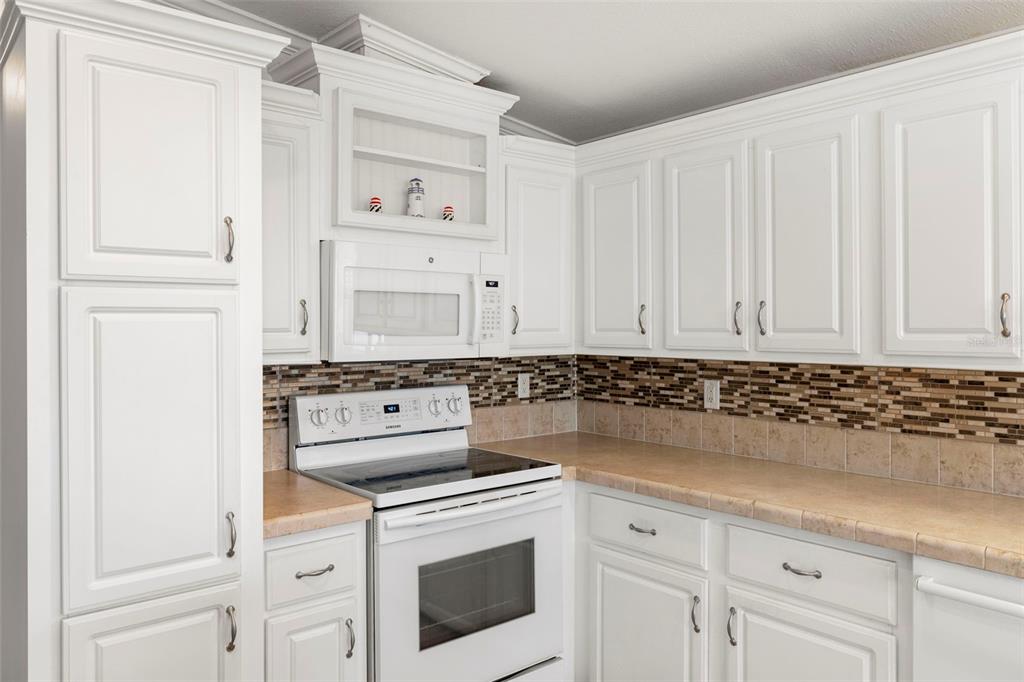 27 Freeman Avenue Punta Gorda, FL 33950 - Photo 6 of 32 a kitchen with white cabinets and white appliances