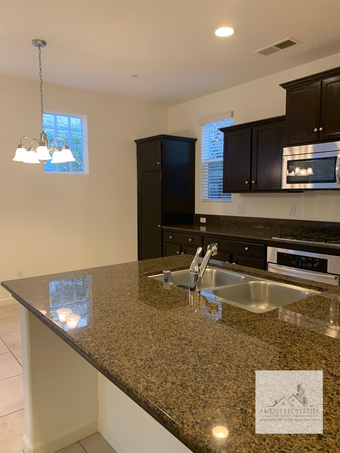 3663 Etchings Way Clovis, CA 93619 - Photo 7 of 26 a kitchen with stainless steel appliances granite countertop a sink a stove and a microwave oven
