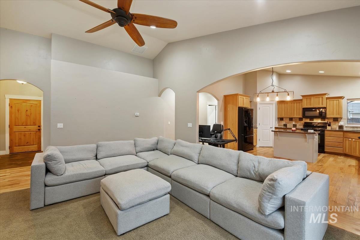 640 Southwest Miner Street Mountain Home, ID 83647 - Photo 14 of 35 Living area with light wood-style floors, high vaulted ceiling, ceiling fan, and arched walkways