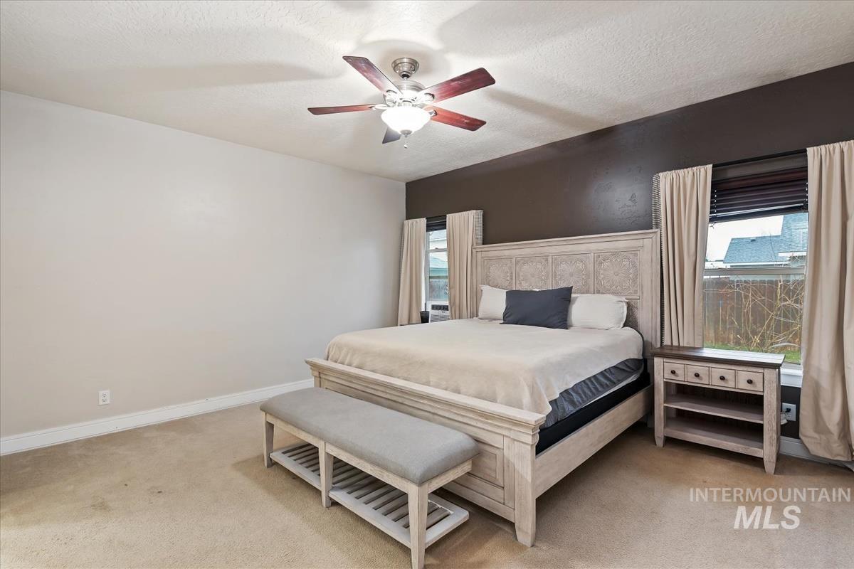 640 Southwest Miner Street Mountain Home, ID 83647 - Photo 24 of 35 Bedroom featuring light colored carpet, a textured ceiling, and ceiling fan