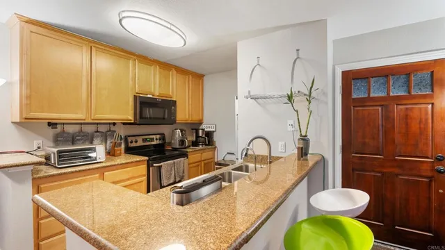 a kitchen with a refrigerator a stove and a sink with wooden floor