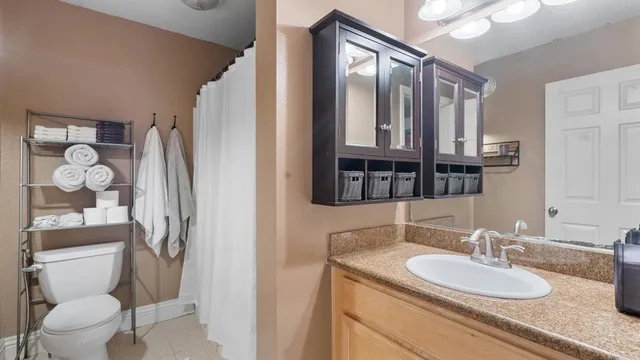 a bathroom with a granite countertop sink toilet and shower