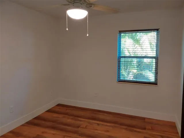 a view of a small space with wooden floor and a window