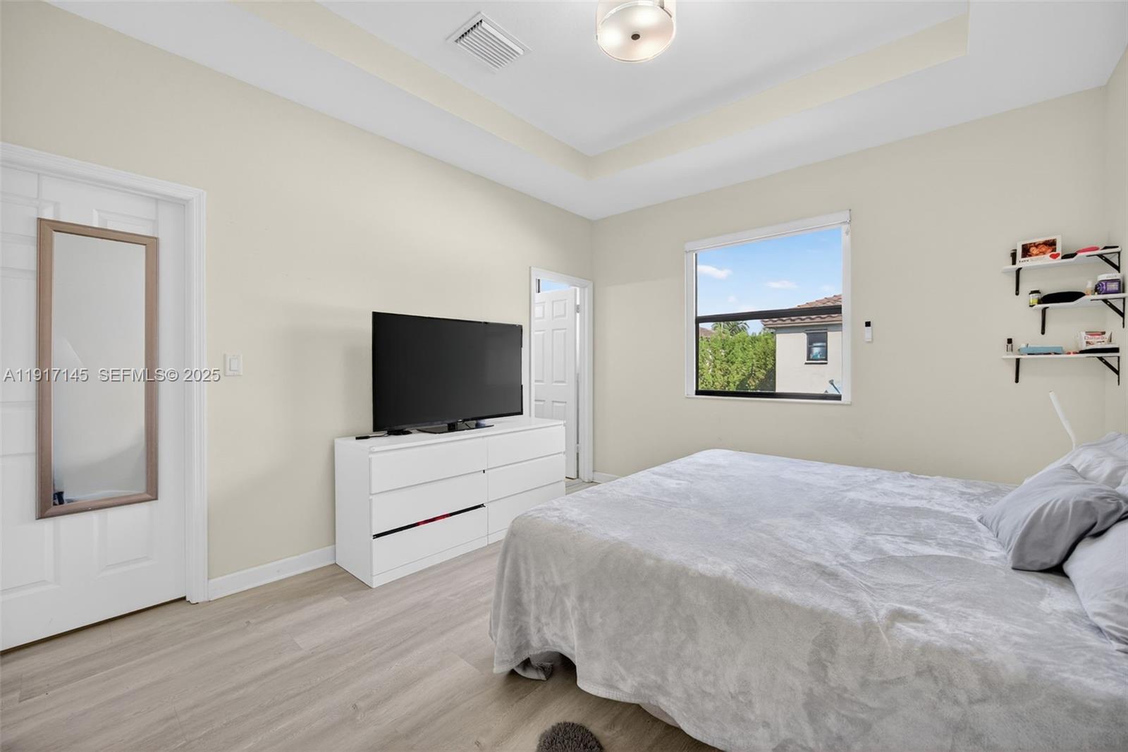 11527 Southwest 248th Lane Homestead, FL 33032 - Photo 17 of 44 a bedroom with a bed and a flat screen tv