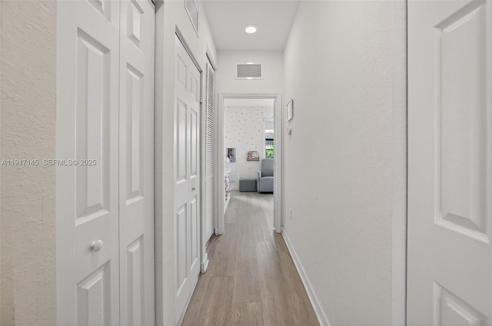 11527 Southwest 248th Lane Homestead, FL 33032 - Photo 21 of 44 a view of a hallway with wooden floor and a bathroom