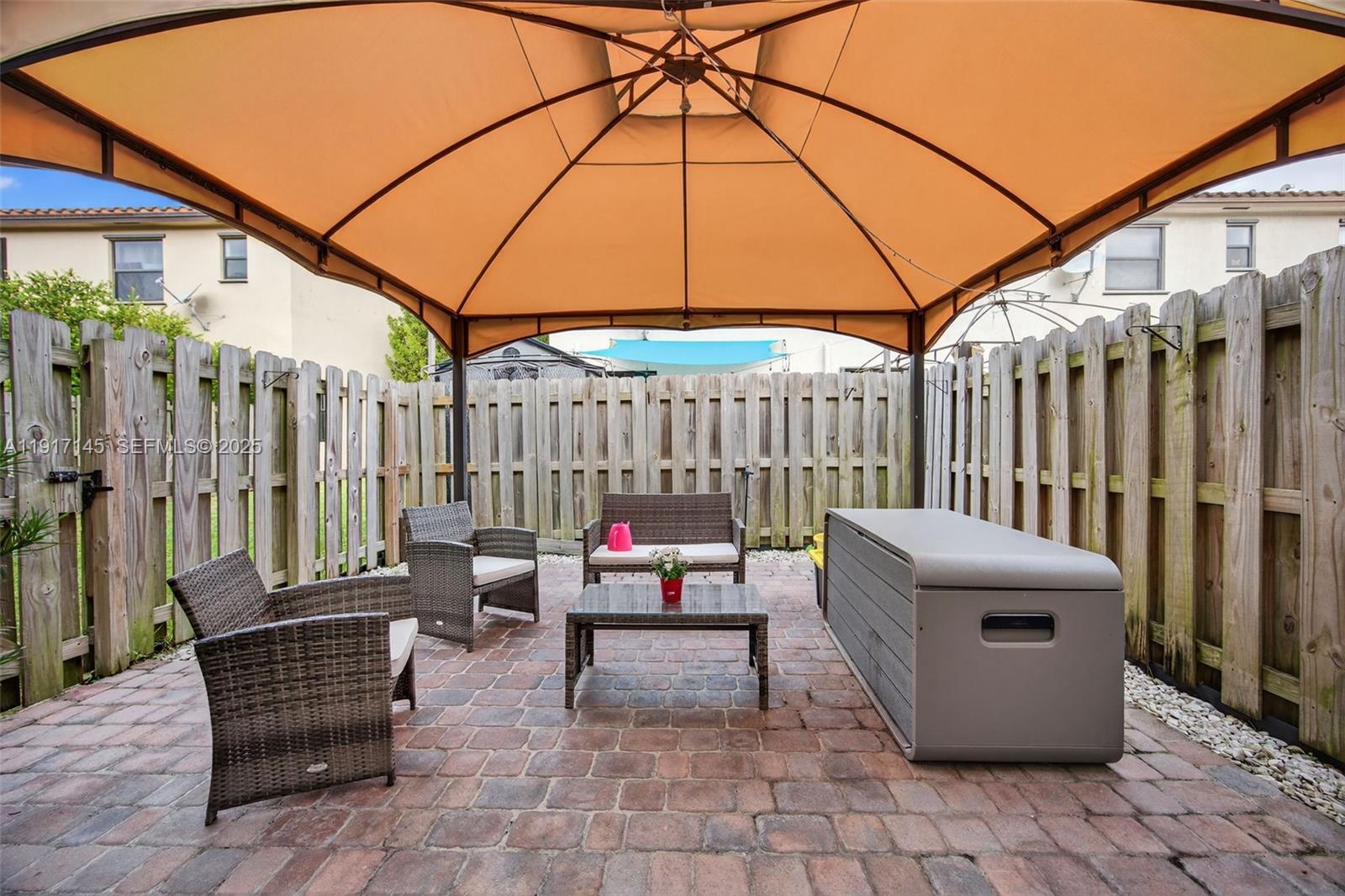 11527 Southwest 248th Lane Homestead, FL 33032 - Photo 32 of 44 a patio with patio couch and umbrella
