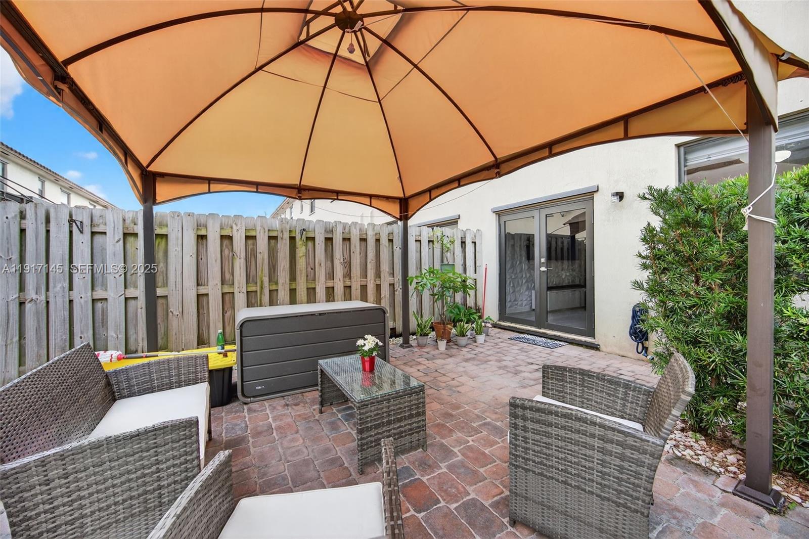 11527 Southwest 248th Lane Homestead, FL 33032 - Photo 33 of 44 a view of a patio with a table and chairs under an umbrella