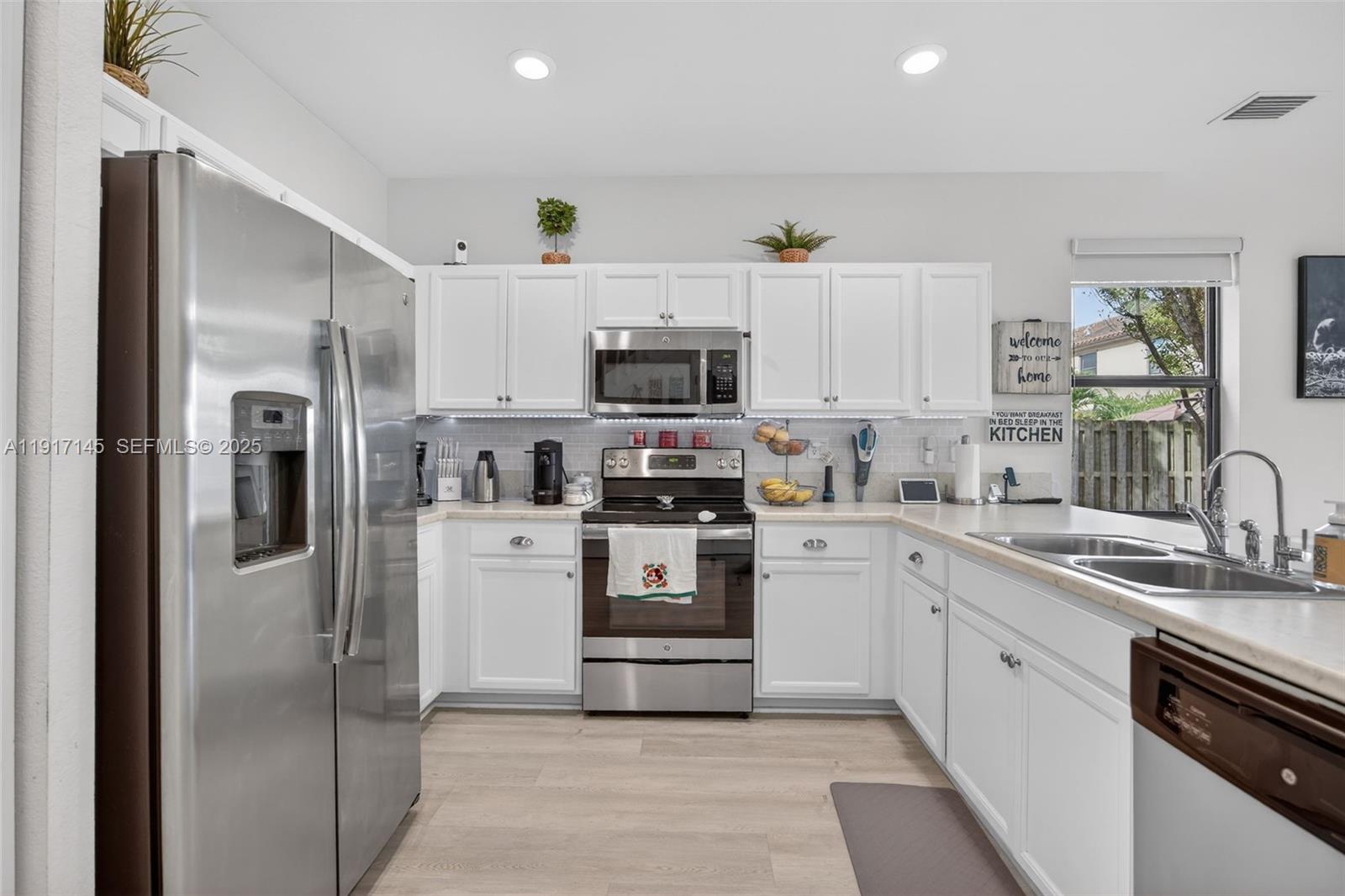 11527 Southwest 248th Lane Homestead, FL 33032 - Photo 8 of 44 a kitchen with white cabinets and stainless steel appliances