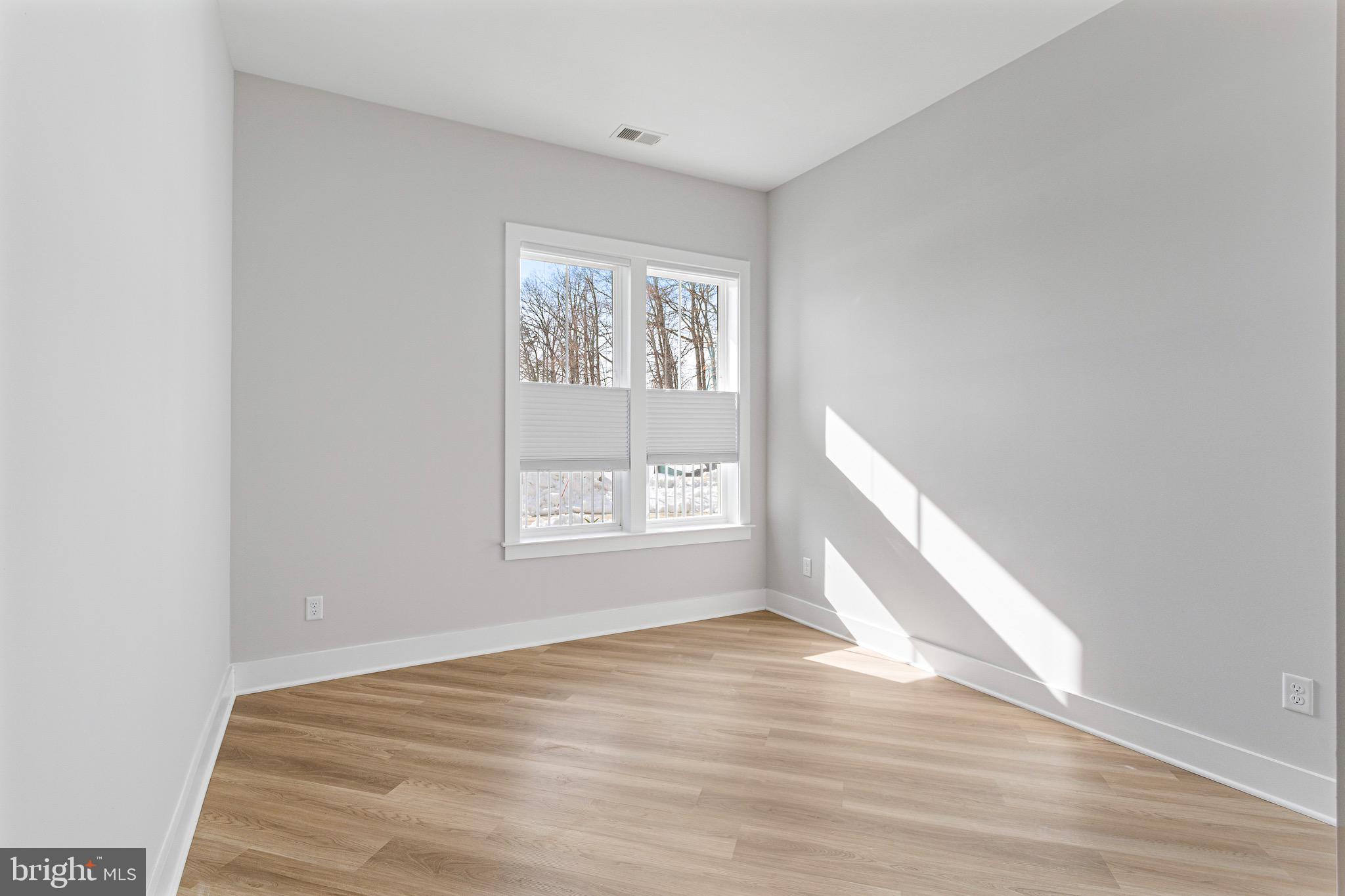 76 Old Mill Bottom Road North, Unit 102 Annapolis, MD 21409 - Photo 28 of 42 a view of an empty room with wooden floor and a window