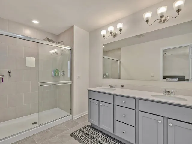 a bathroom with a double vanity sink mirror and shower