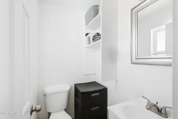 a bathroom with a toilet a sink and mirror