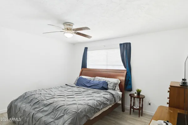 a bedroom with a bed and wooden floor