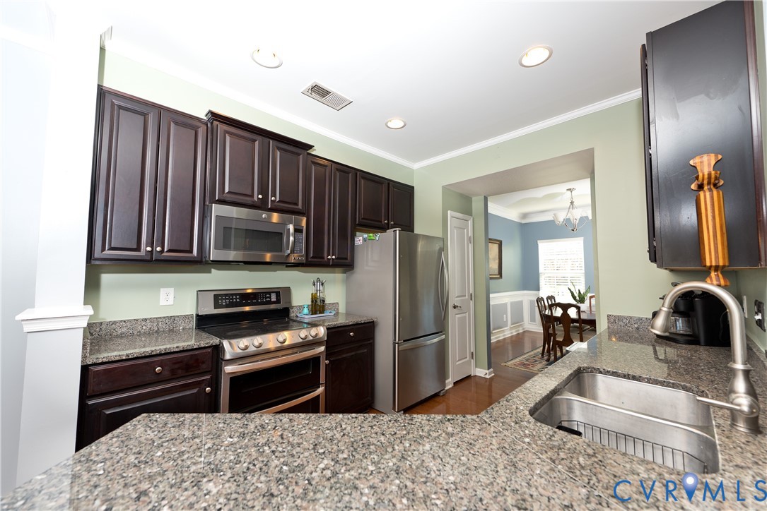 10343 Colony Bee Place Mechanicsville, VA 23116 - Photo 12 of 50 a kitchen with granite countertop a refrigerator stove and sink