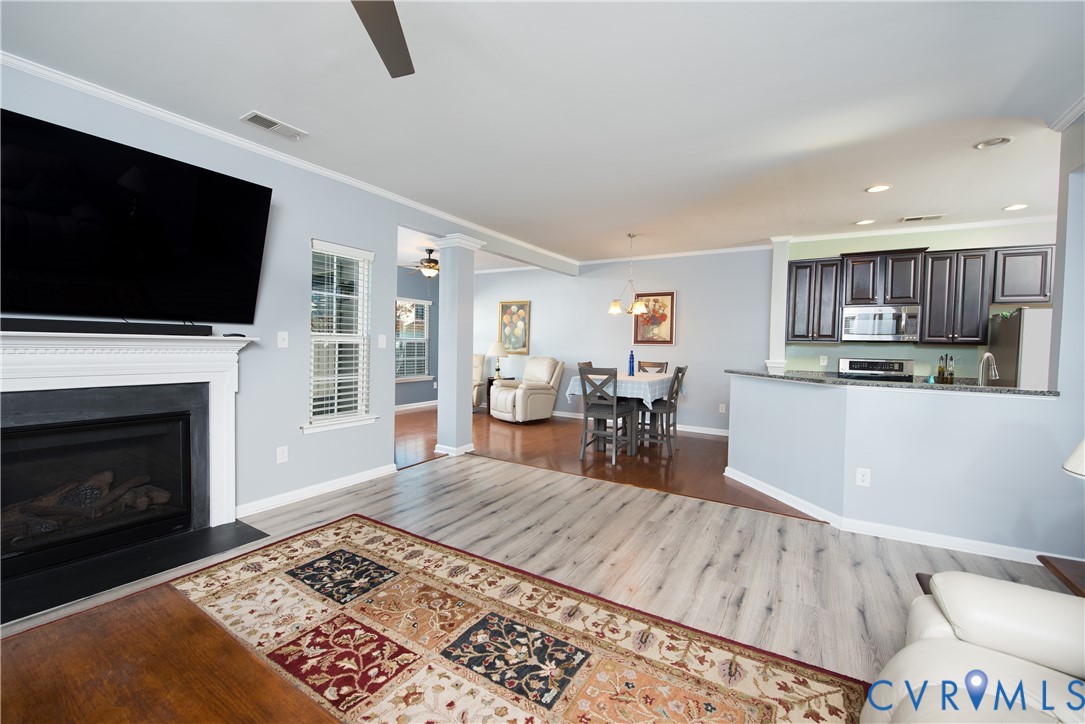 10343 Colony Bee Place Mechanicsville, VA 23116 - Photo 9 of 50 a living room with stainless steel appliances furniture a fireplace a flat screen tv and kitchen view