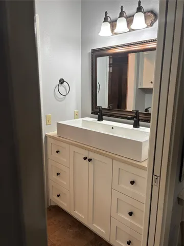 a bathroom with a sink vanity and a mirror