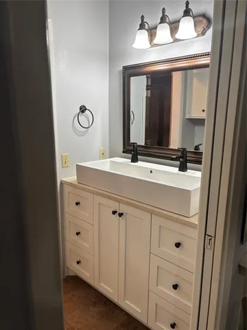 a bathroom with a sink vanity and a mirror
