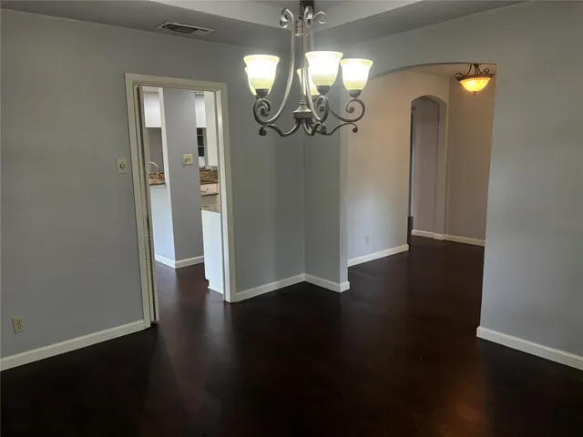 an empty room with wooden floor and mirror