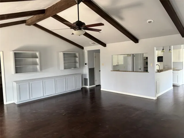 a view of an empty room with a window and fireplace