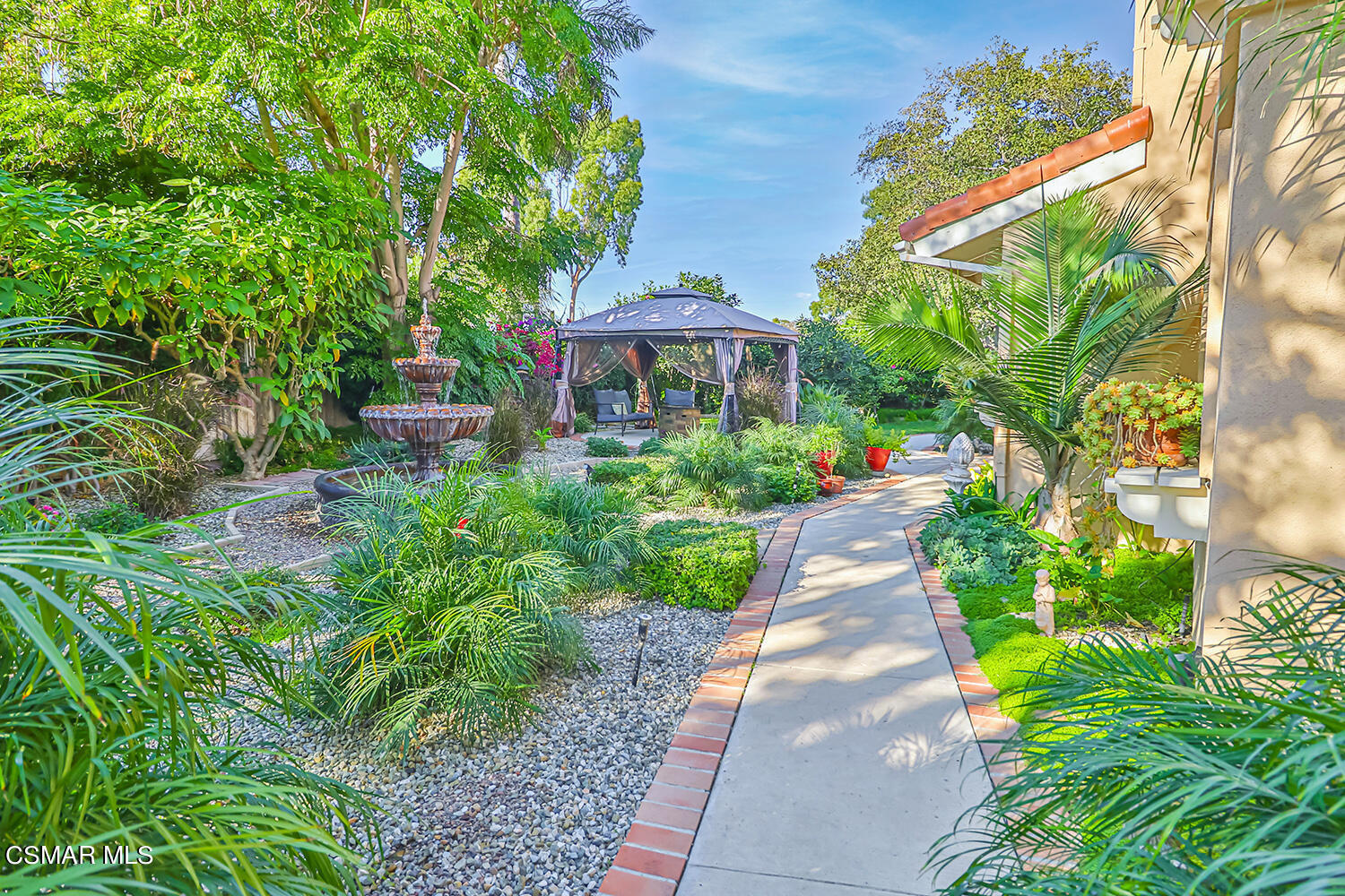 2911 Fanshell Walk Oxnard, CA 93035 - Photo 3 of 42 a view of a garden with lawn chairs under an umbrella