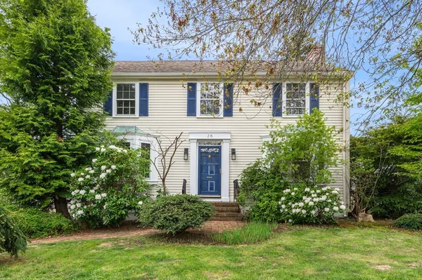a front view of a house with a garden and plants