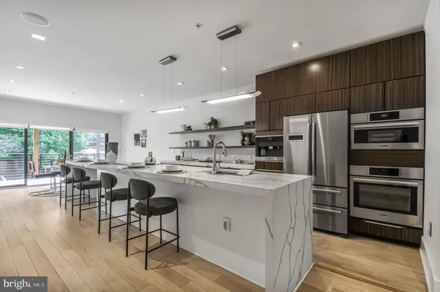 a kitchen with kitchen island a sink stove and refrigerator