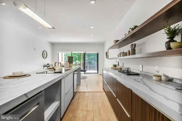 a kitchen with stainless steel appliances kitchen island granite countertop a stove a sink a refrigerator and chairs