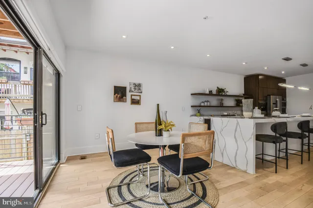 a dining room with wooden floor and a floor to ceiling window