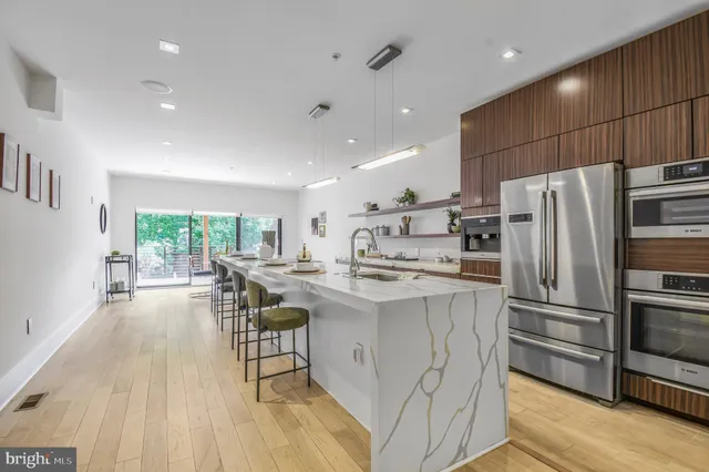 a kitchen with kitchen island a counter top space a sink stainless steel appliances and cabinets