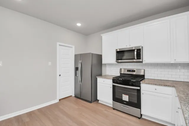 a kitchen with stainless steel appliances a refrigerator stove and microwave