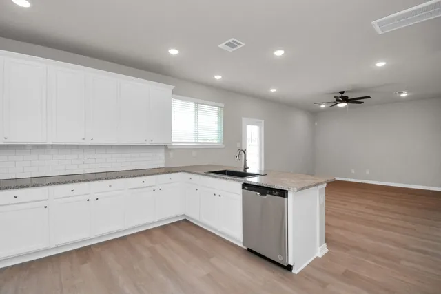 a kitchen with granite countertop a sink and cabinets