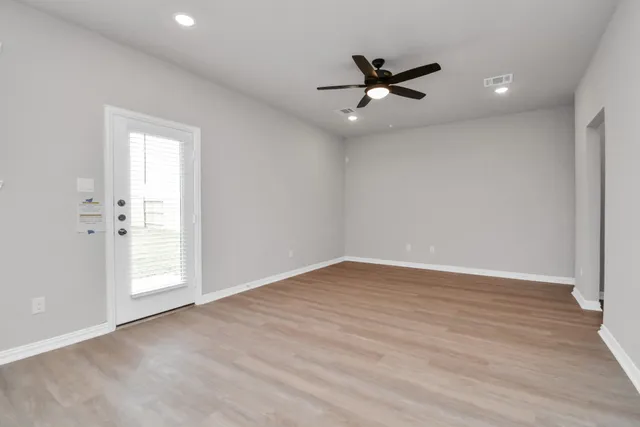 wooden floor in an empty room with a window