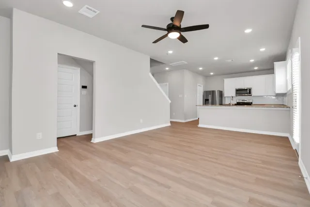 a view of a kitchen with a ceiling fan a kitchen and a window